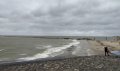 Hoog water tijdens een storm op de Brouwersdam. Zee water loopt over het strand achter de Blokkendam langs.